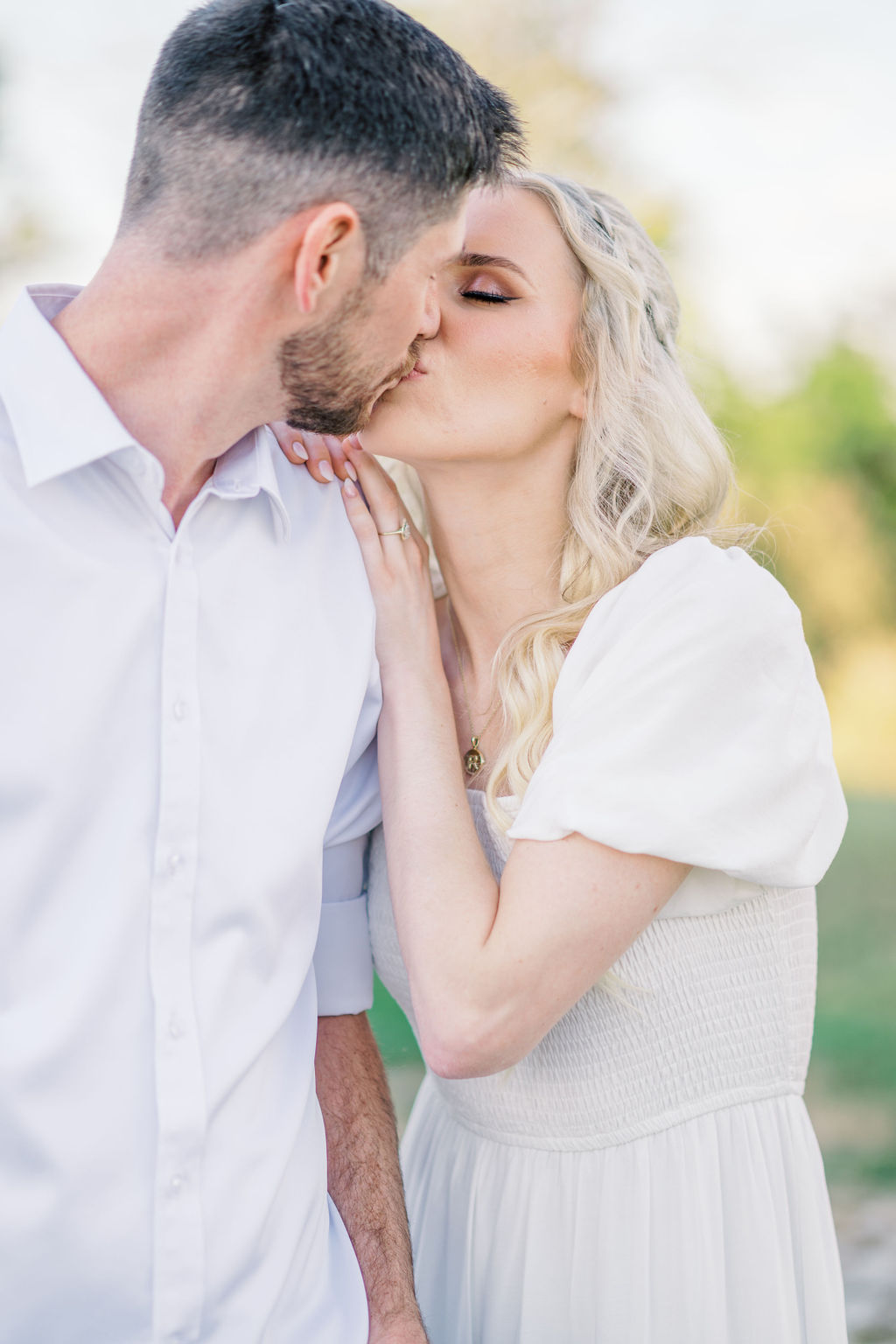 A romantic embrace in front of The Bell of Camden Point at sunset