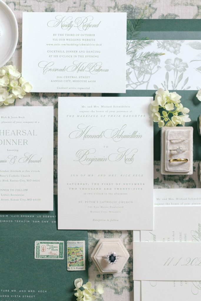 Flat lay of wedding invitation suite, rings, and stamps for a Crossroads Hotel wedding in Kansas City