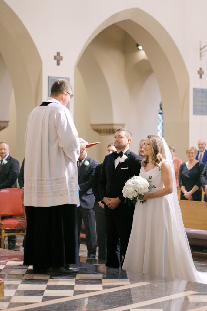 Bride and groom standing at the altar during their wedding ceremony inside a Kansas City church