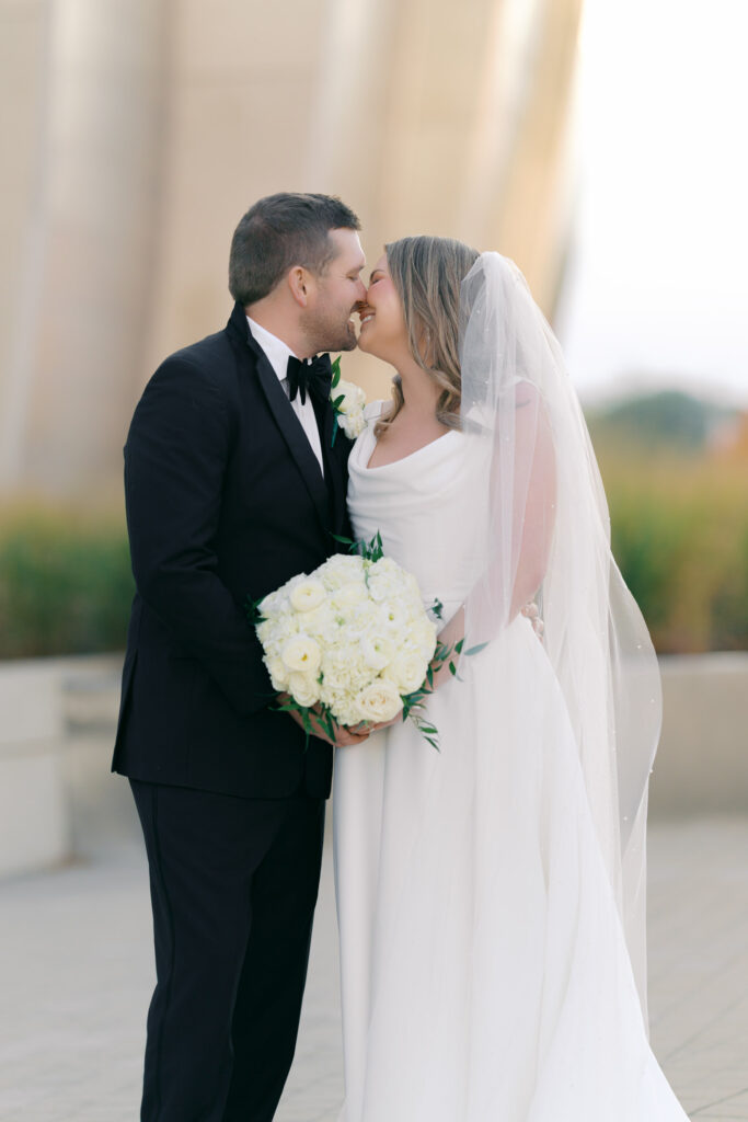 Bride and groom sharing a kiss during romantic wedding portraits