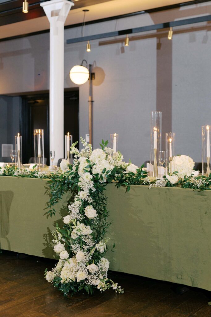 Wedding sweetheart table with cascading white floral arrangement and candlelight