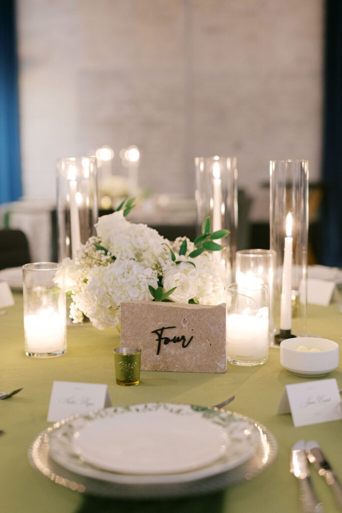 Wedding reception table centerpiece with white flowers and candles