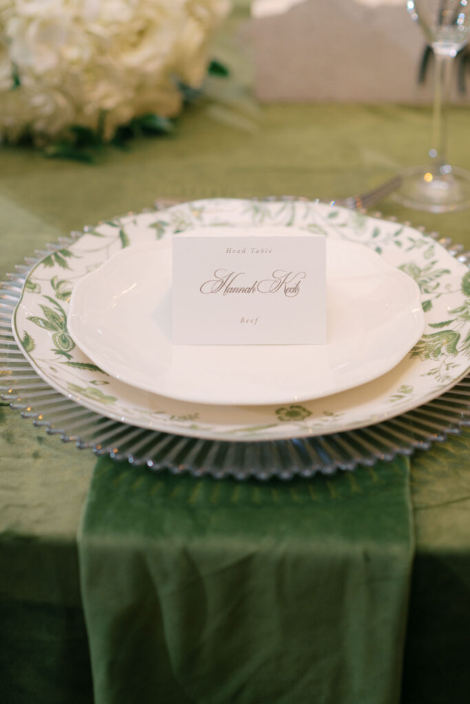 Head table place setting with custom menu card and green floral dinner plate
