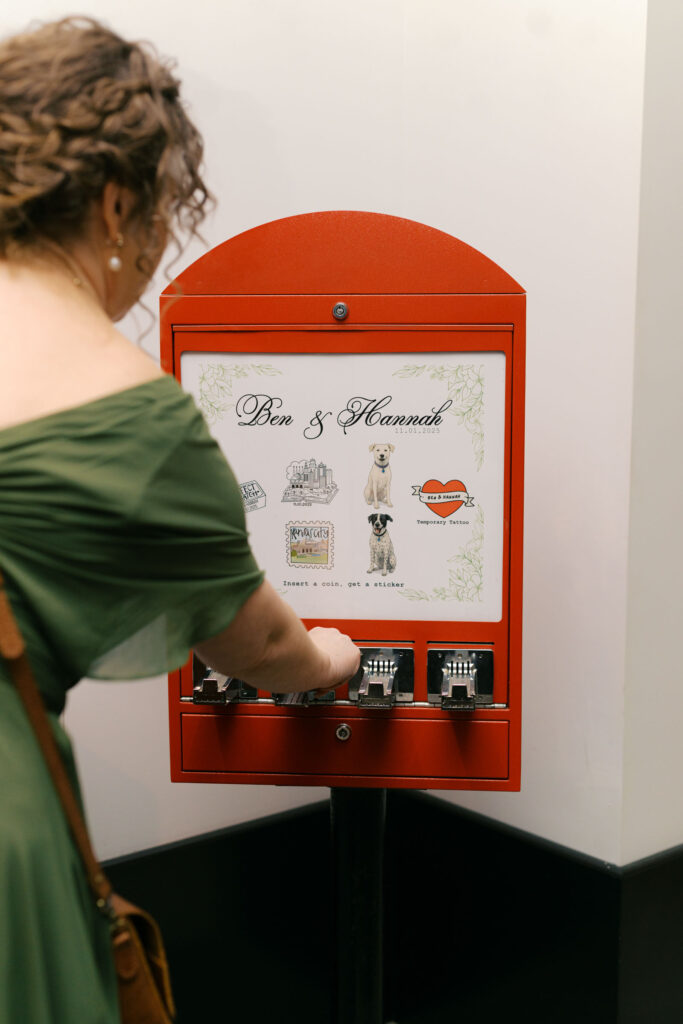 Guest using a vintage sticker vending machine during wedding reception