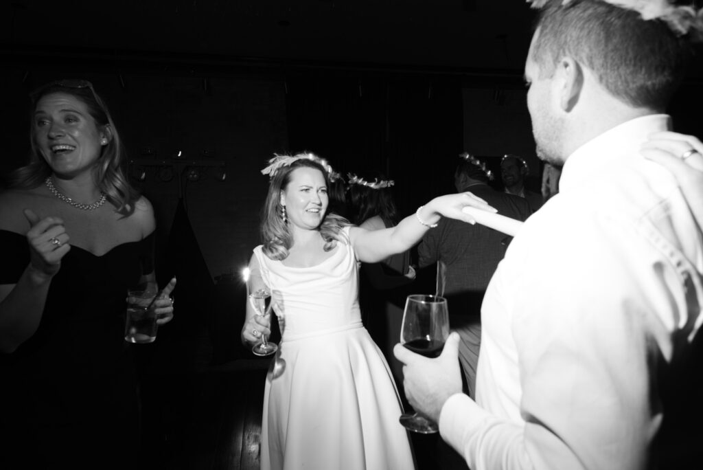Bride dancing with guests during lively wedding reception dance floor moment