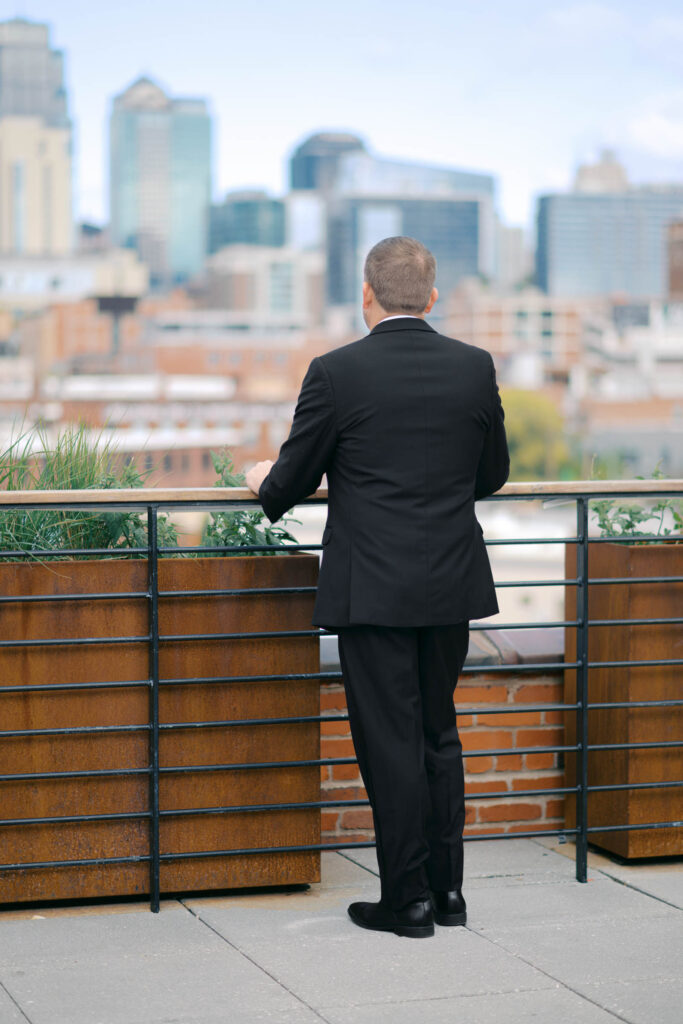 Groom overlooking the Kansas City skyline from the Crossroads Hotel rooftop